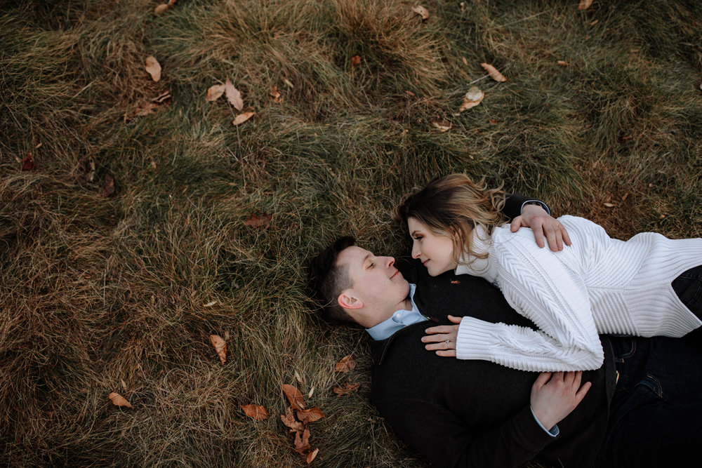 couple-laying-on-grass-engagement-photos
