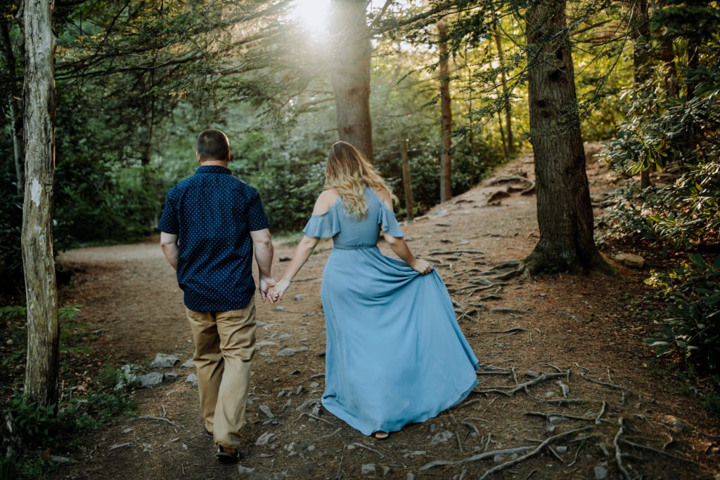 Couple holding hands and walking in the woods