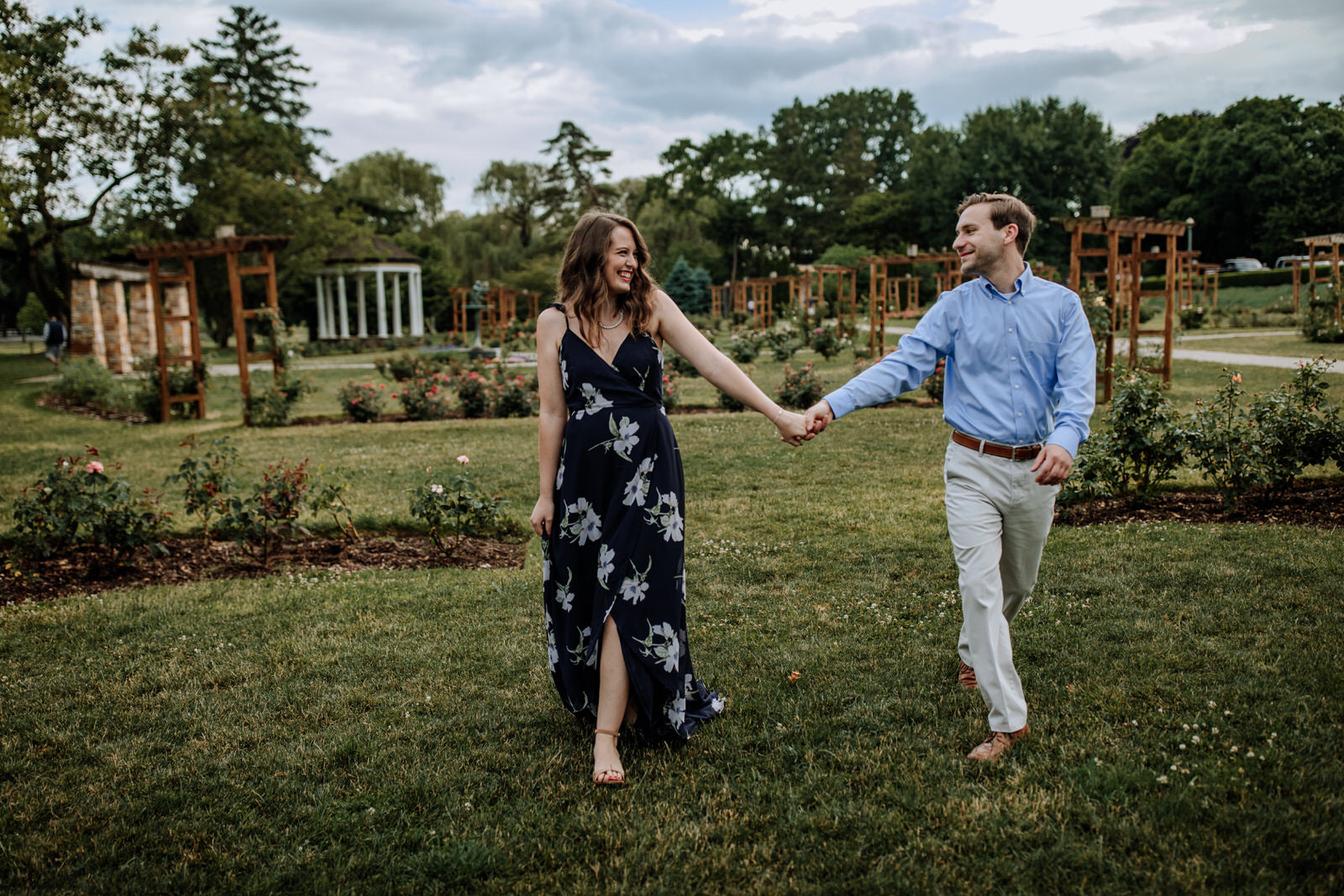 Man and woman holding hands and walking together through Allentown Rose Gardens