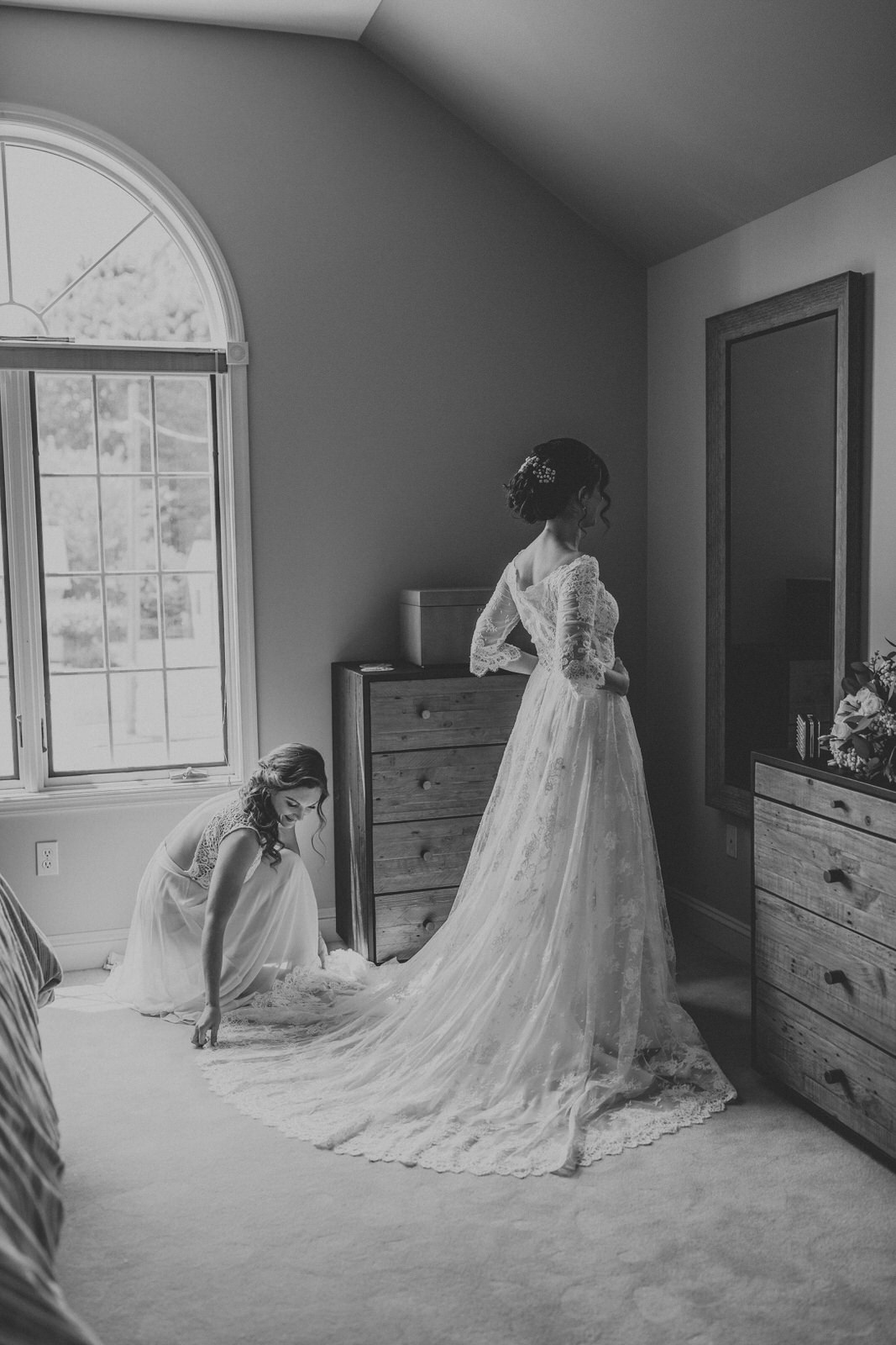 Bride looking at herself in the mirror after getting into her wedding dress