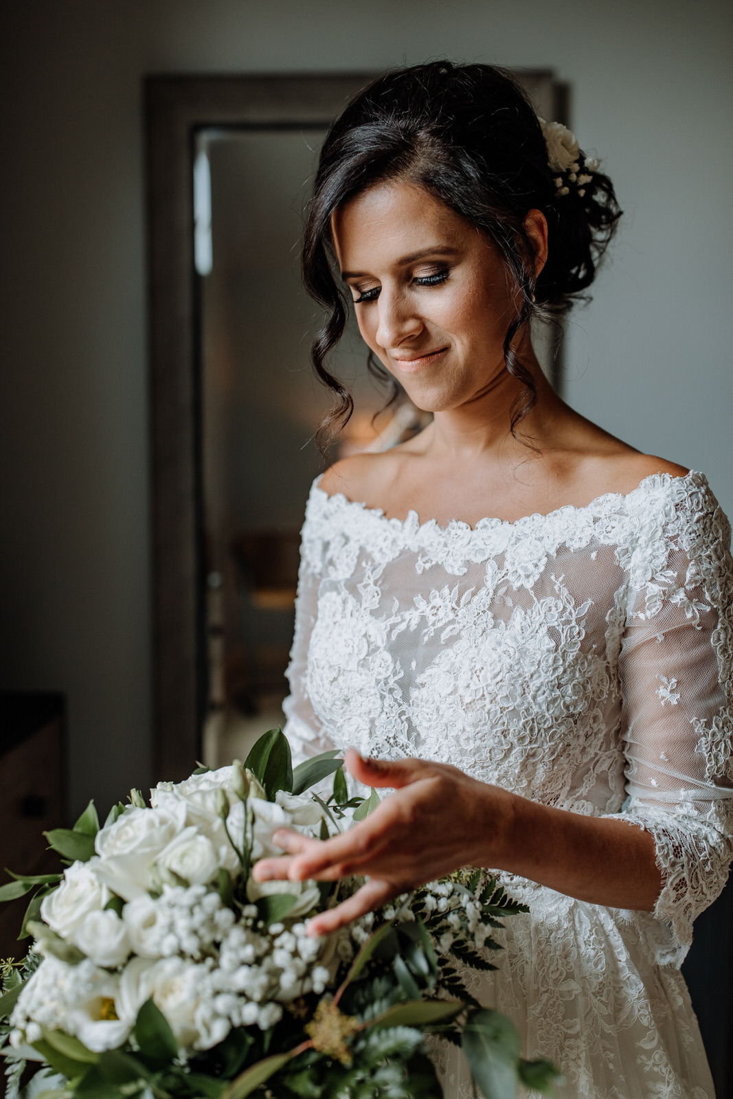 Woman in wedding dress looking at her flower bouquet