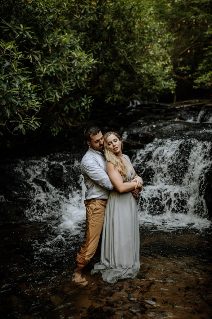 Man and woman in front of a small waterfall