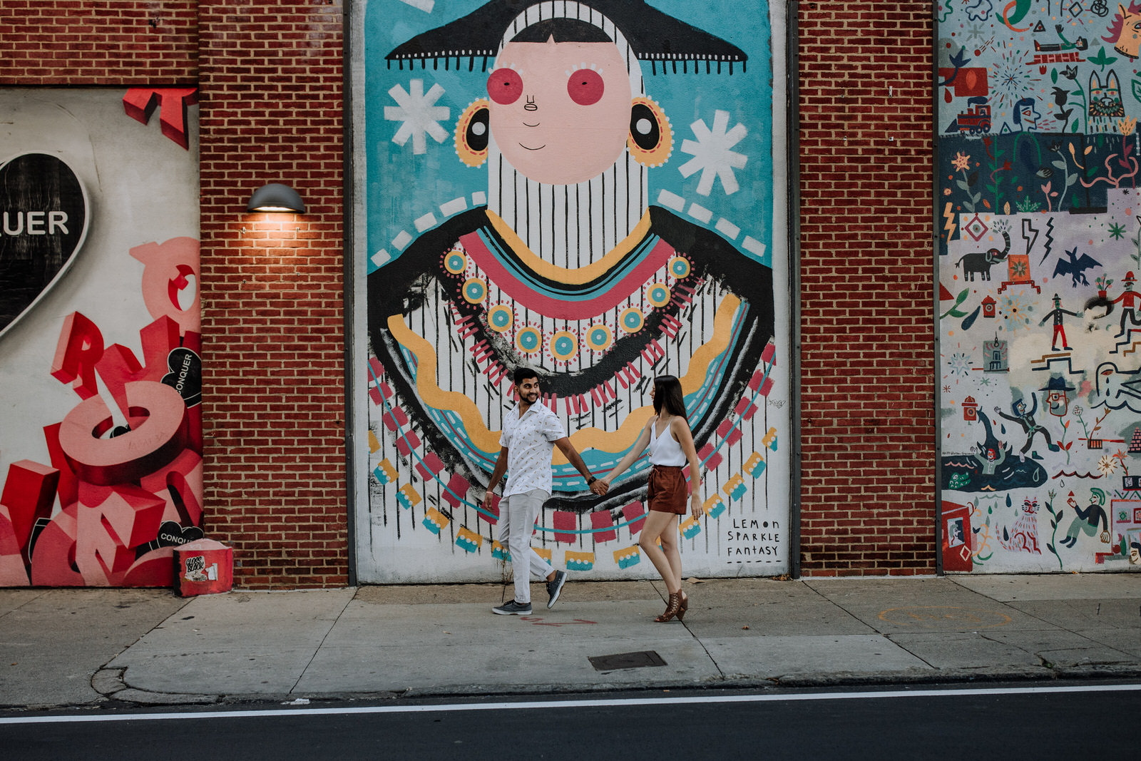 Couple walking in front of Race Street murals in Philadelphia, PA