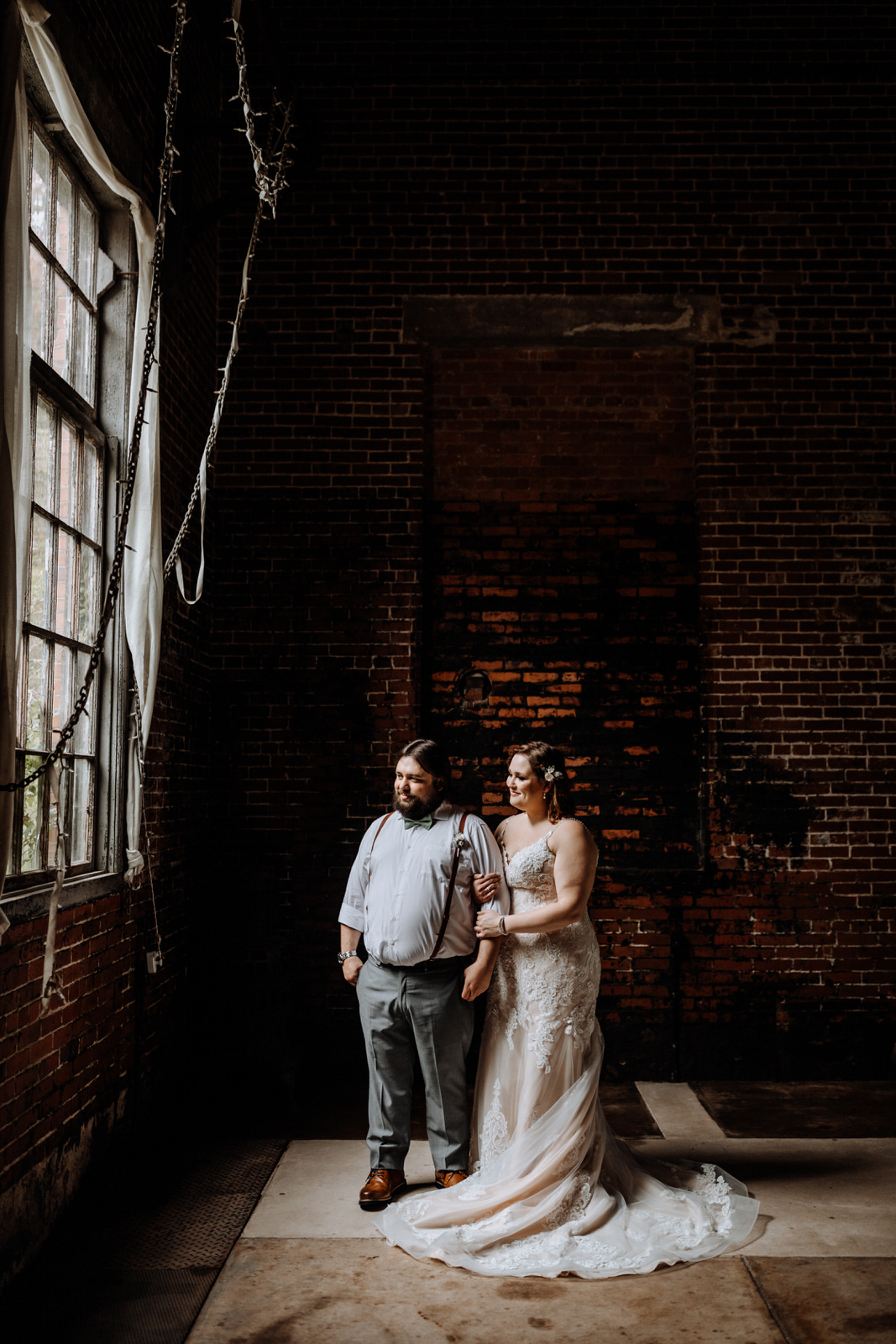 Bride & Groom Portrait in front of a brick wall with window light