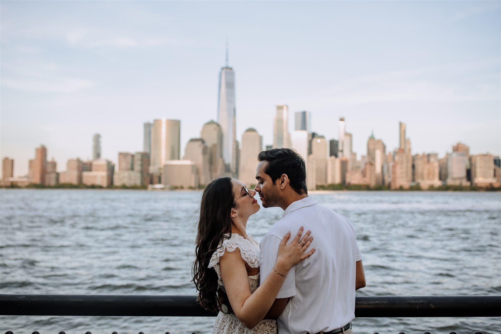 Couple about to kiss with New York City skyline behind them